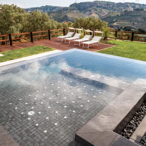 Piscina infinity a sfioro incastonata in un giardino collinare a Settingiano, Calabria.